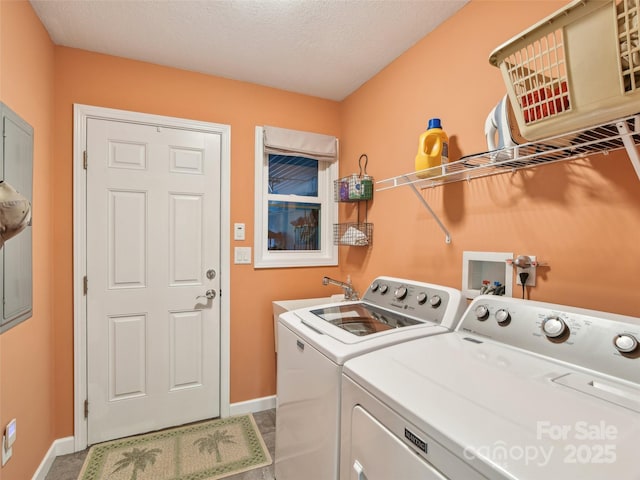 laundry area with laundry area, baseboards, washer and clothes dryer, a textured ceiling, and a sink
