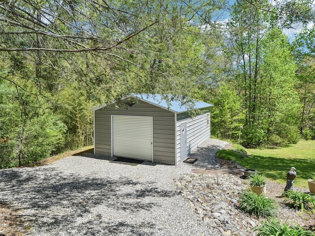 garage featuring a view of trees and a shed