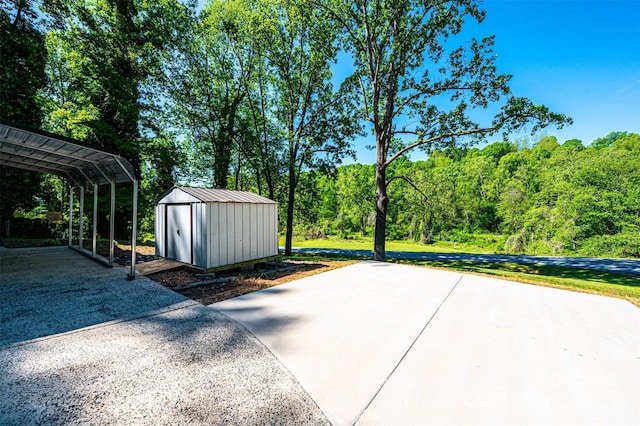 1018 Autumn Ln, Hickory, NC 28602 - view of patio with a wooded view, aphalt driveway, an outbuilding, and a storage unit