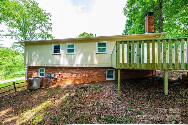 1018 Autumn Ln, Hickory, NC 28602 - back of property with a chimney, a deck, central air condition unit, brick siding, and fence