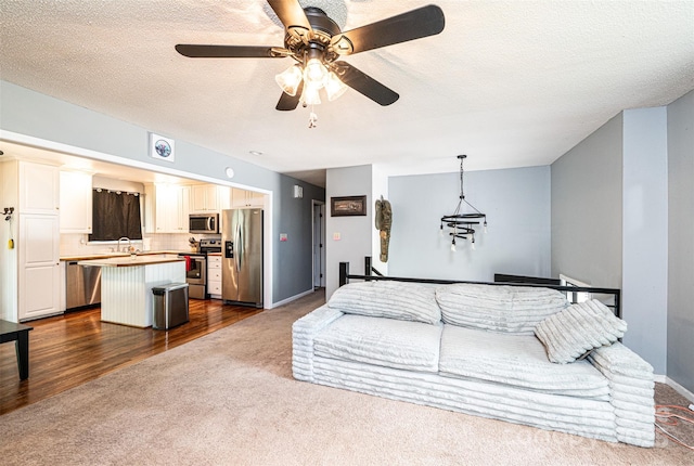 1018 Autumn Ln, Hickory, NC 28602 - living room with baseboards, ceiling fan, dark colored carpet, and a textured ceiling