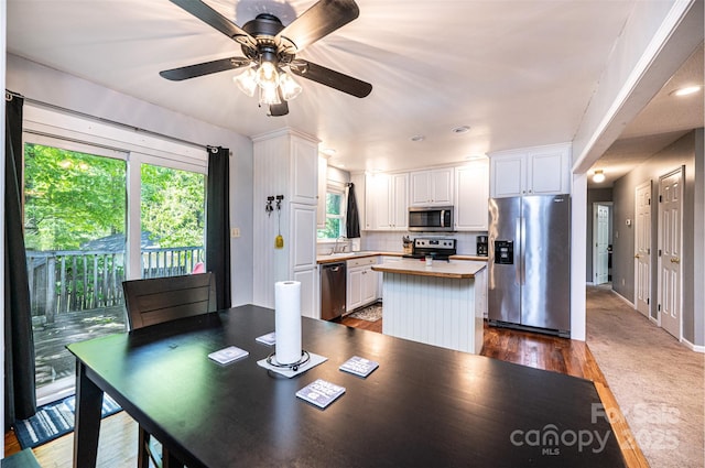 1018 Autumn Ln, Hickory, NC 28602 - kitchen featuring ceiling fan, a kitchen island, tasteful backsplash, white cabinets, and stainless steel appliances