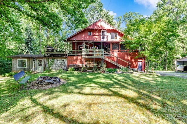76 Archer Rd, Saluda, NC 28773 - rear view of house featuring an outdoor fire pit, a lawn, stairway, and a wooden deck
