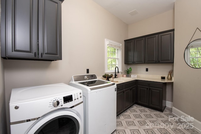 laundry room with a sink, a healthy amount of sunlight, cabinet space, and washer and dryer