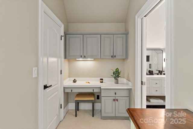 home office with built in desk and light carpet