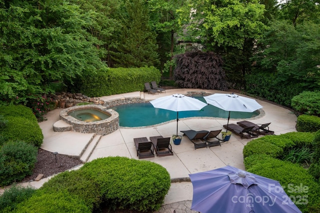 view of swimming pool with a pool with connected hot tub and a patio area