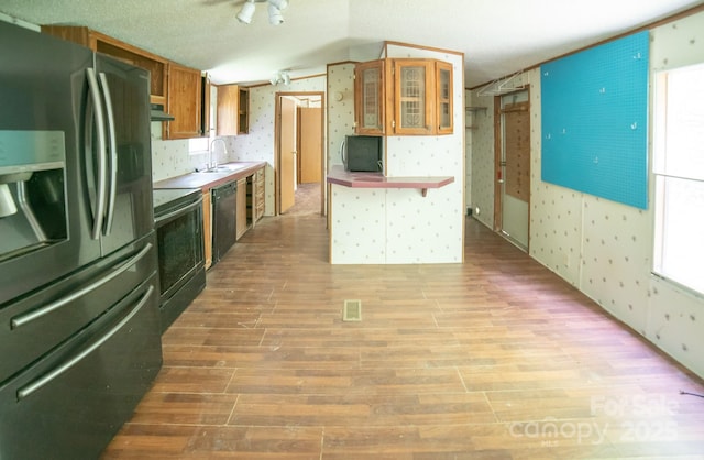 kitchen featuring electric range, wallpapered walls, stainless steel fridge, light wood-style flooring, and dishwasher