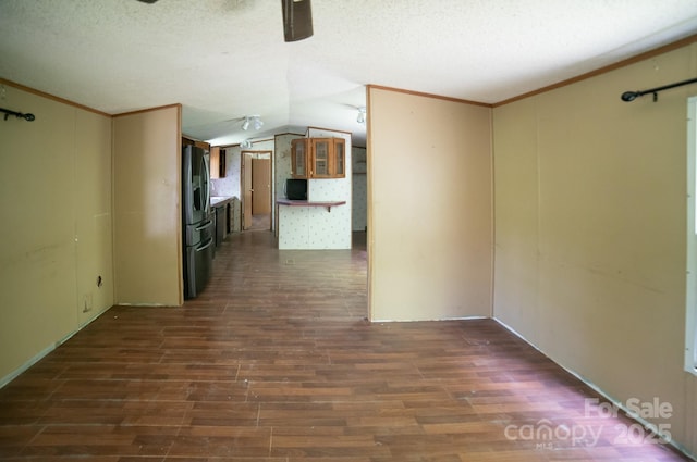 unfurnished room featuring crown molding, a textured ceiling, vaulted ceiling, and dark wood-type flooring