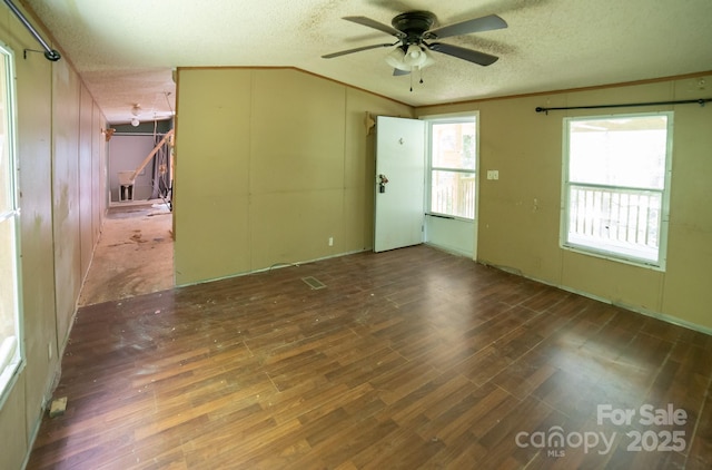 spare room with a ceiling fan, a textured ceiling, ornamental molding, and wood finished floors