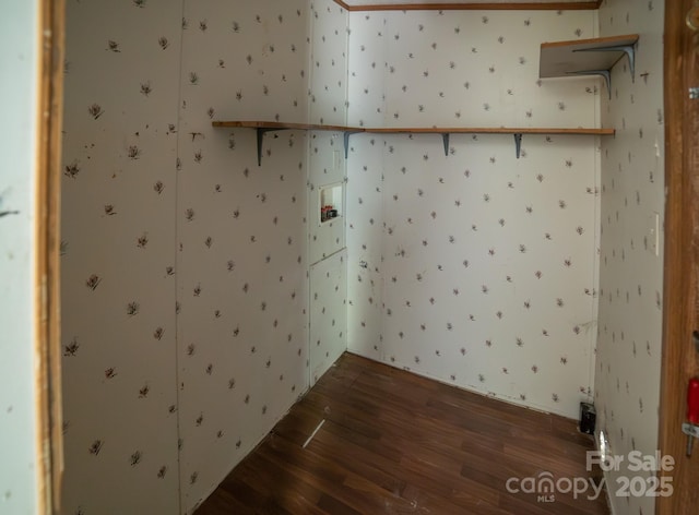 spare room featuring wallpapered walls and wood finished floors