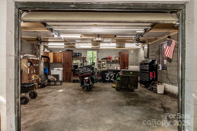 7733 Skyline Dr, Sherrills Ford, NC 28673 - garage featuring a workshop area, washer / dryer, a garage door opener, and concrete block wall