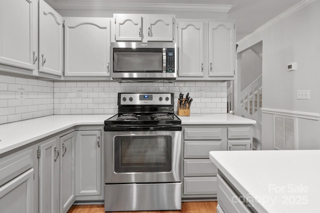 9214 Arbourgate Meadows Ln, Charlotte, NC 28277 - kitchen with decorative backsplash, visible vents, appliances with stainless steel finishes, light countertops, and ornamental molding