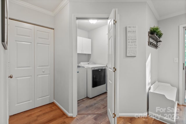 9214 Arbourgate Meadows Ln, Charlotte, NC 28277 - washroom featuring ornamental molding, cabinet space, light wood-style flooring, and washer and clothes dryer