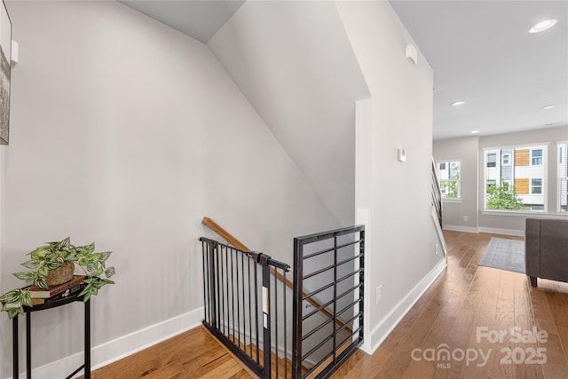 stairs with recessed lighting, baseboards, and wood finished floors