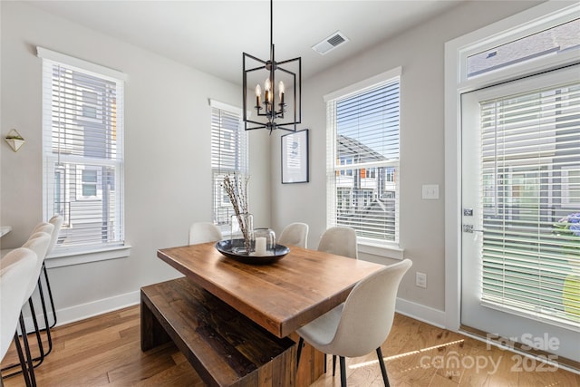 dining room with baseboards, visible vents, plenty of natural light, and light wood-style flooring
