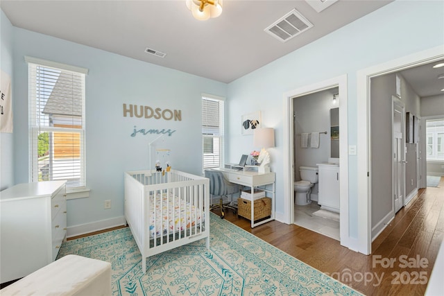bedroom featuring baseboards, wood finished floors, and visible vents