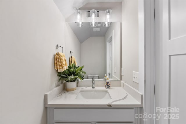 half bathroom featuring vanity and toilet