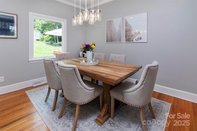 1514 Wensley Dr, Charlotte, NC 28210 - dining room featuring baseboards, ornamental molding, wood finished floors, and a chandelier