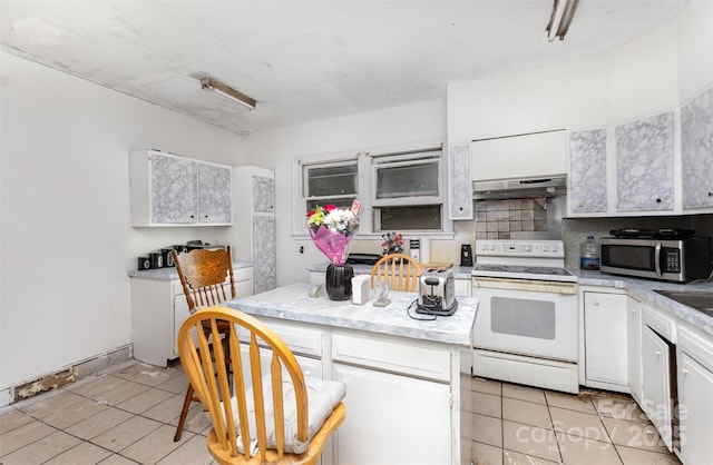 2622 Hemphill St, Charlotte, NC 28208 - kitchen with electric range, stainless steel microwave, under cabinet range hood, light tile patterned flooring, and white cabinets