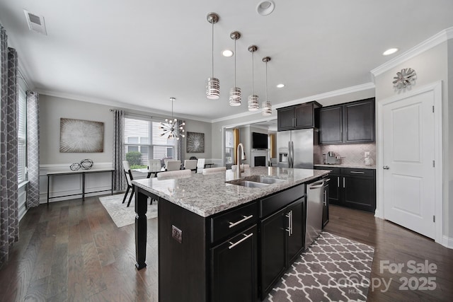 8702 Aspinwall Dr, Charlotte, NC 28216 - kitchen with a sink, stainless steel appliances, a breakfast bar area, ornamental molding, and a chandelier