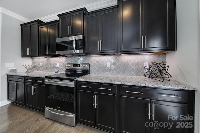 8702 Aspinwall Dr, Charlotte, NC 28216 - kitchen featuring stainless steel appliances, dark cabinets, ornamental molding, wood finished floors, and decorative backsplash