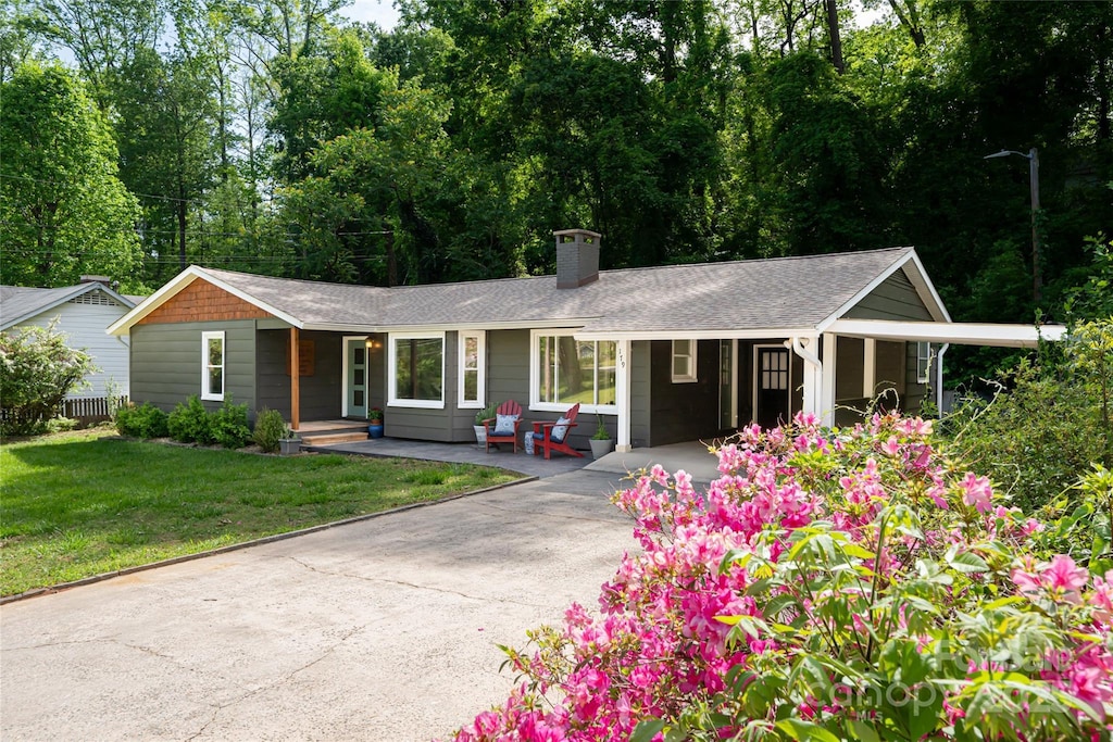 179 Grady Ave, Tryon, NC 28782 - ranch-style house featuring covered porch, a front lawn, a chimney, a carport, and driveway