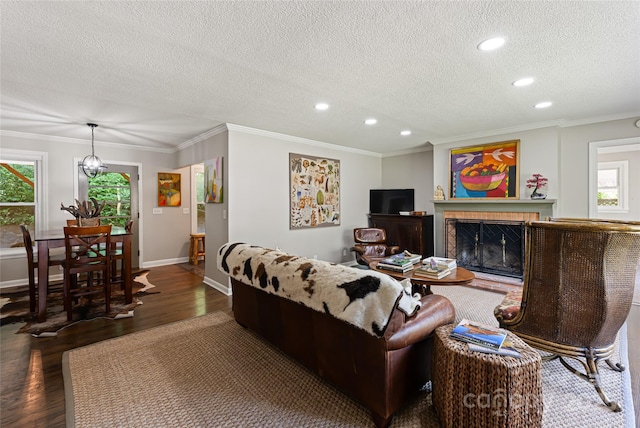 living area featuring baseboards, recessed lighting, a textured ceiling, and wood finished floors