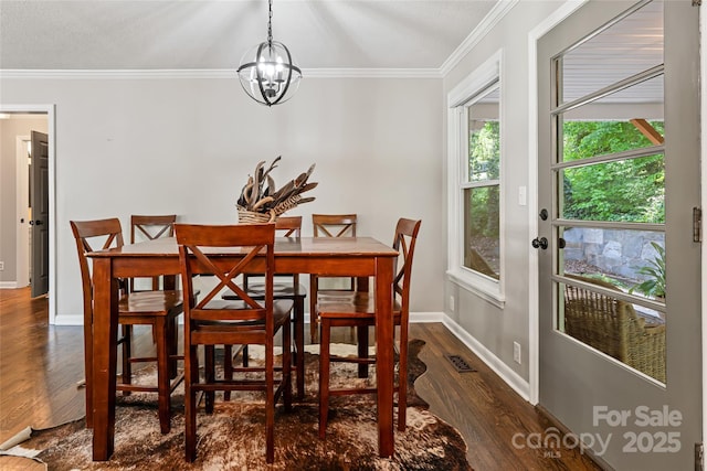 dining space with visible vents, ornamental molding, baseboards, dark wood-type flooring, and a chandelier