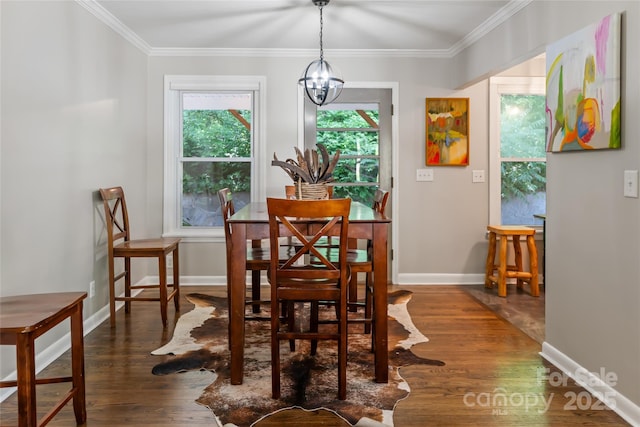 dining area featuring crown molding, dark wood-style flooring, and a chandelier