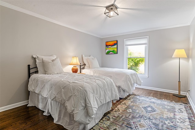 bedroom with crown molding, baseboards, and wood finished floors