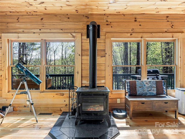 detailed view of a wood stove, wooden walls, and wood finished floors