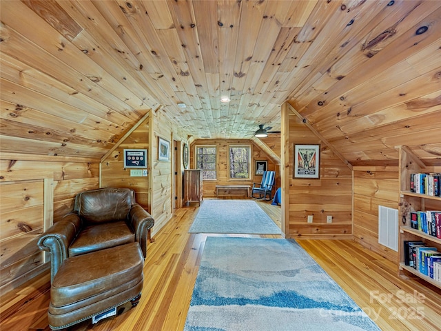 sitting room with wood ceiling, lofted ceiling, wood-type flooring, and wood walls