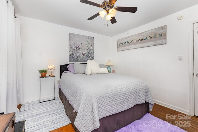 bedroom with baseboards, wood finished floors, and ceiling fan