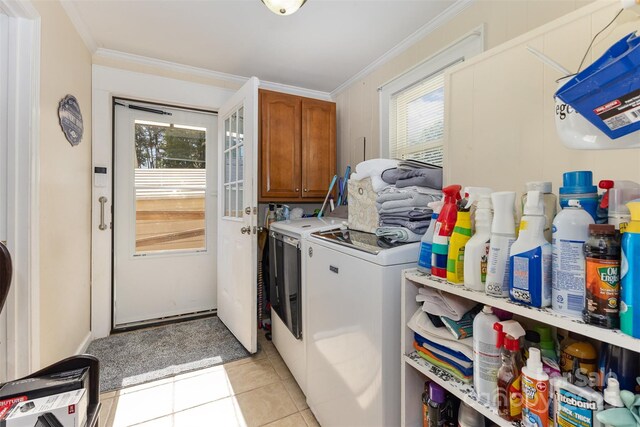 washroom featuring plenty of natural light, cabinet space, light tile patterned floors, ornamental molding, and washing machine and dryer