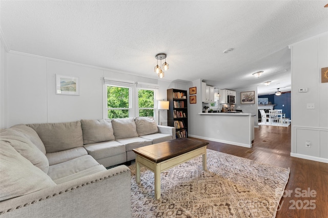 9 Ruby Dr, Hendersonville, NC 28792 - living area with an inviting chandelier, ornamental molding, a textured ceiling, and dark wood-style floors