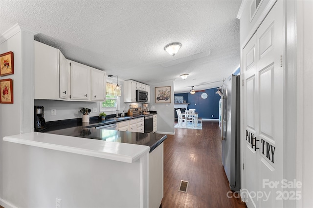 9 Ruby Dr, Hendersonville, NC 28792 - kitchen with appliances with stainless steel finishes, white cabinets, a peninsula, and a textured ceiling