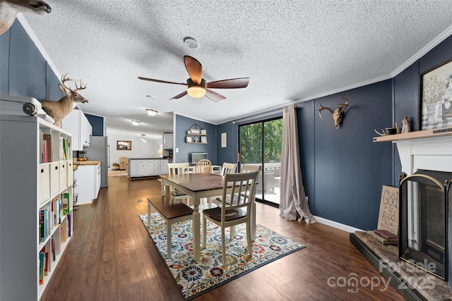 9 Ruby Dr, Hendersonville, NC 28792 - dining area featuring ceiling fan, dark wood-style flooring, a textured ceiling, crown molding, and a fireplace with raised hearth