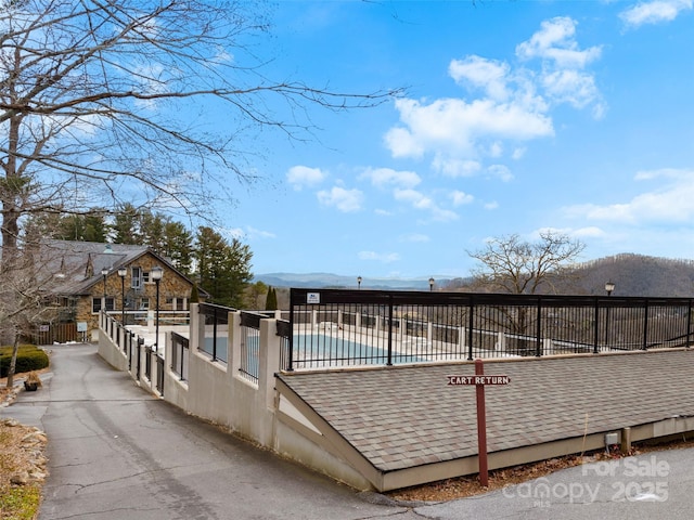 44 Chip Shot Ct, Mills River, NC 28759 - rear view of house featuring fence, a shingled roof, a mountain view, and a pool