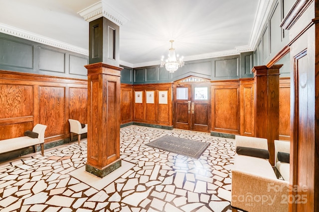 301 W 10th St W, Charlotte, NC 28202 - entryway with ornate columns, inlaid floor details, a decorative wall, crown molding, and a chandelier