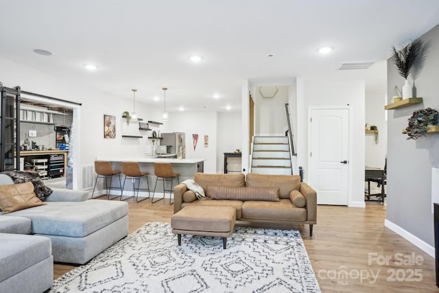 16427 Cozy Cove Rd, Charlotte, NC 28278 - living room featuring light wood-type flooring, stairway, recessed lighting, baseboards, and a barn door