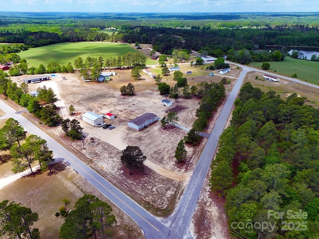 birds eye view of property featuring a water view, a view of trees, and golf course view