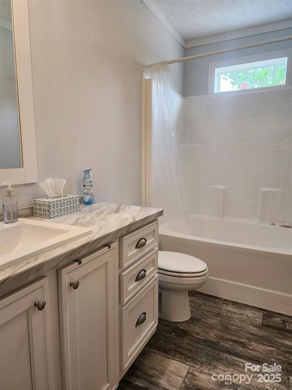 bathroom with vanity, toilet, a textured ceiling, shower / bath combination with curtain, and wood finished floors