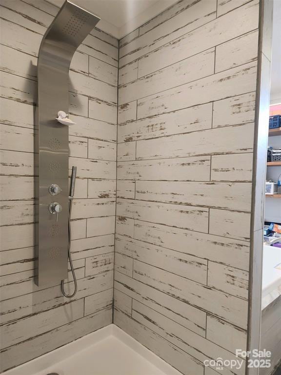 full bathroom with wooden walls and tiled shower
