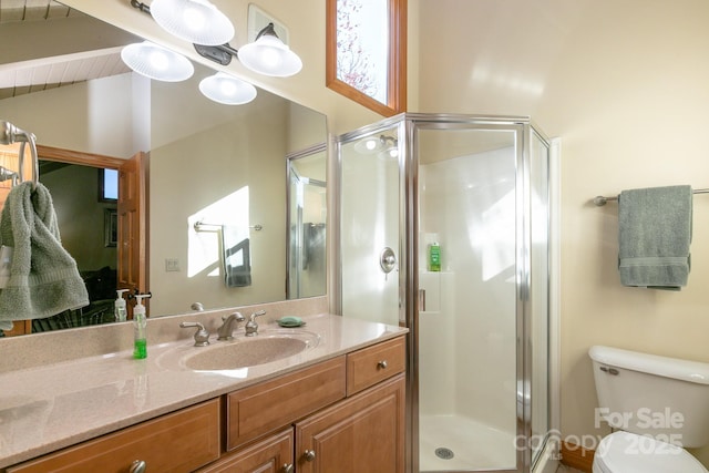 bathroom with a stall shower, vaulted ceiling, vanity, and toilet
