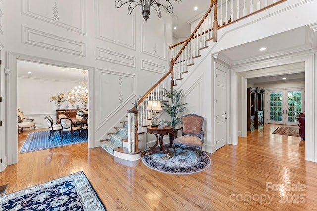3314 Leamington Ln, Charlotte, NC 28226 - entrance foyer with a decorative wall, a chandelier, stairs, crown molding, and wood finished floors