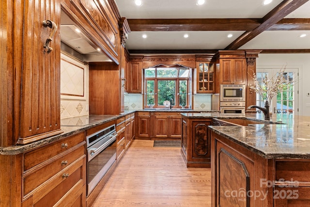 3314 Leamington Ln, Charlotte, NC 28226 - kitchen featuring stainless steel appliances, light wood-style flooring, brown cabinetry, premium range hood, and beamed ceiling