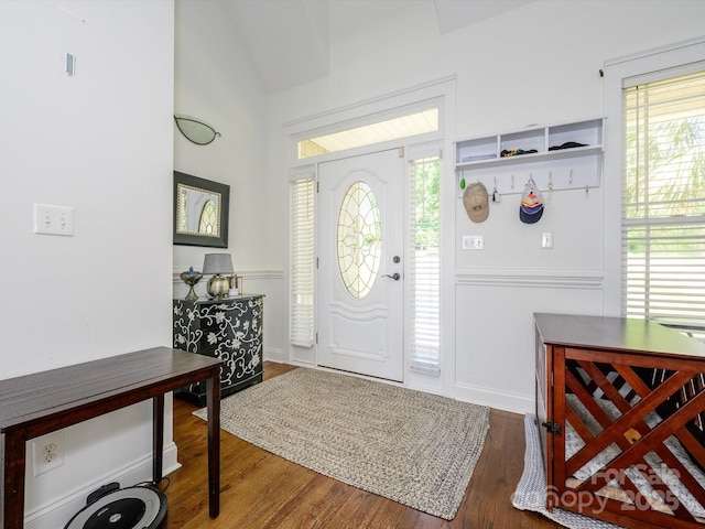 foyer with vaulted ceiling, baseboards, and wood finished floors