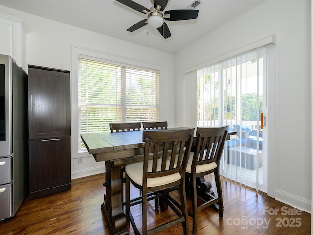 dining room featuring baseboards, dark wood finished floors, ceiling fan, and visible vents