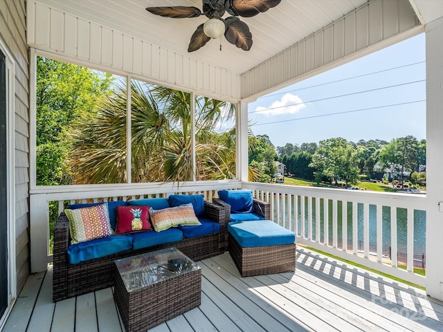 wooden terrace with an outdoor hangout area, a water view, and a ceiling fan