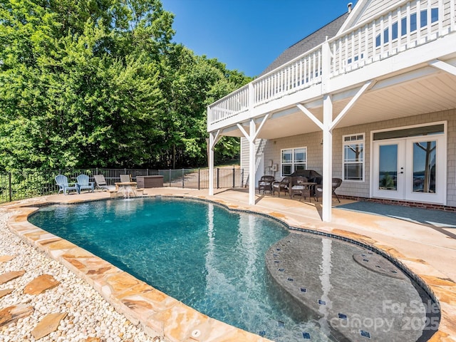 view of pool featuring french doors, a patio area, fence, and a fenced in pool